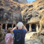 entrance view of Elephanta Caves Mumbai with rock cut pillars and visitors