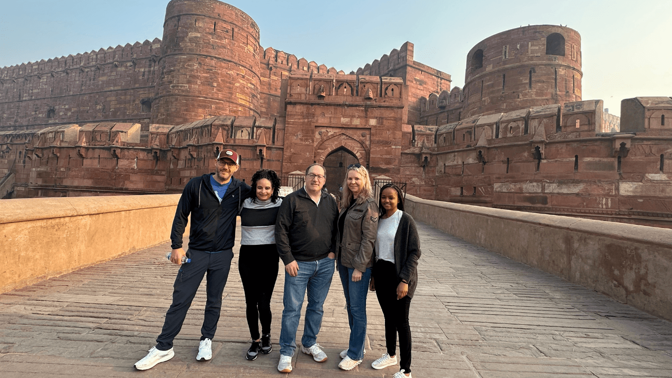 Group of tourists posing at the historic Agra Fort, a UNESCO World Heritage Site in India.
