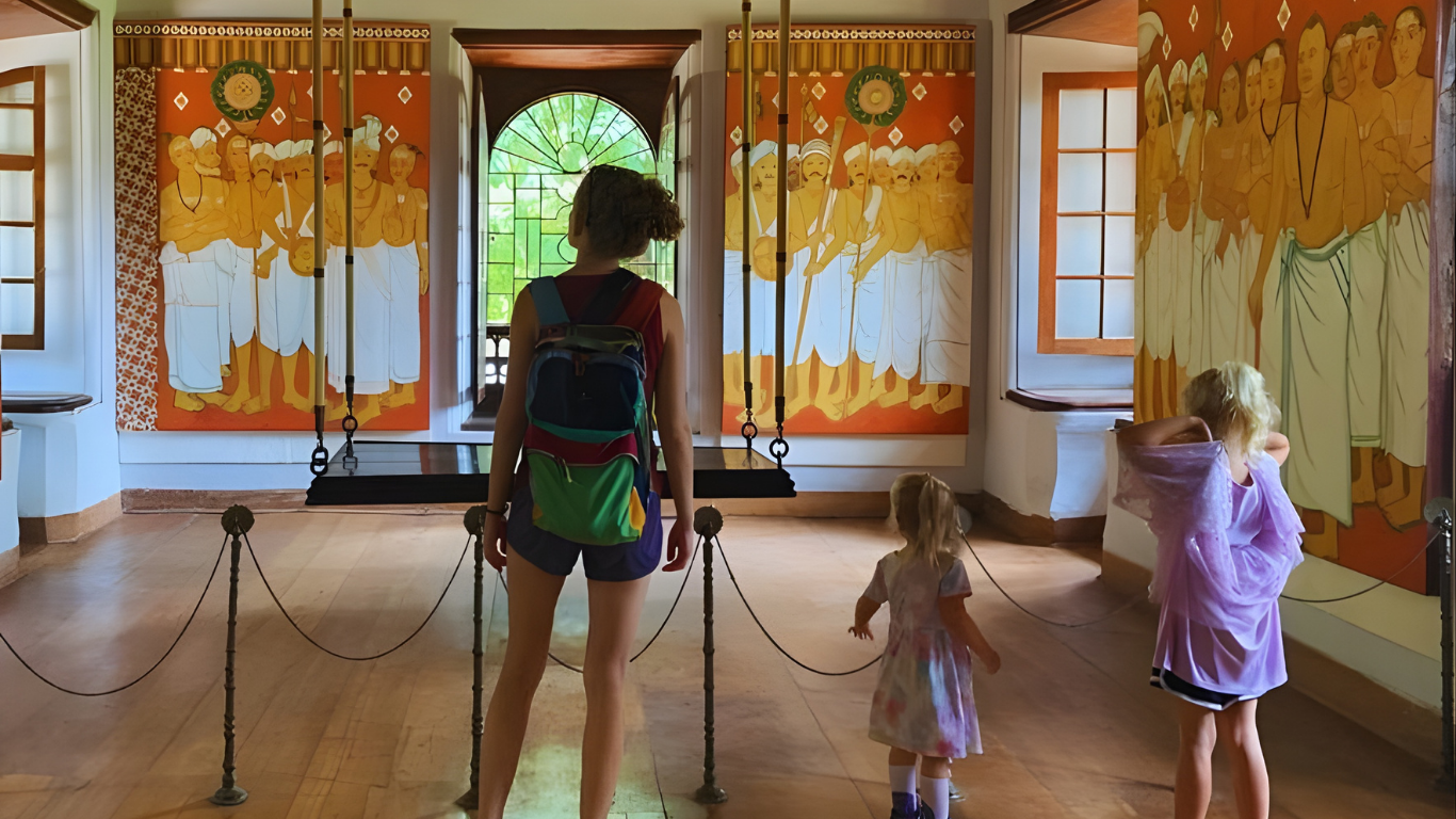 Visitors exploring traditional Kerala murals inside a heritage palace