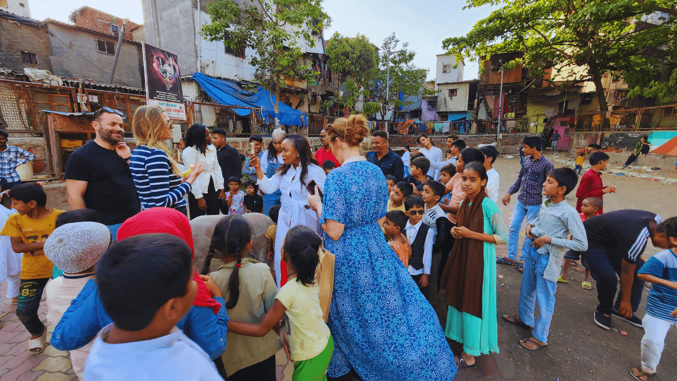 Travelers interacting with local children during a community visit in Dharavi Mumbai