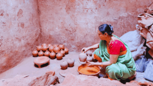 Woman shaping traditional clay pots inside a pottery workshop