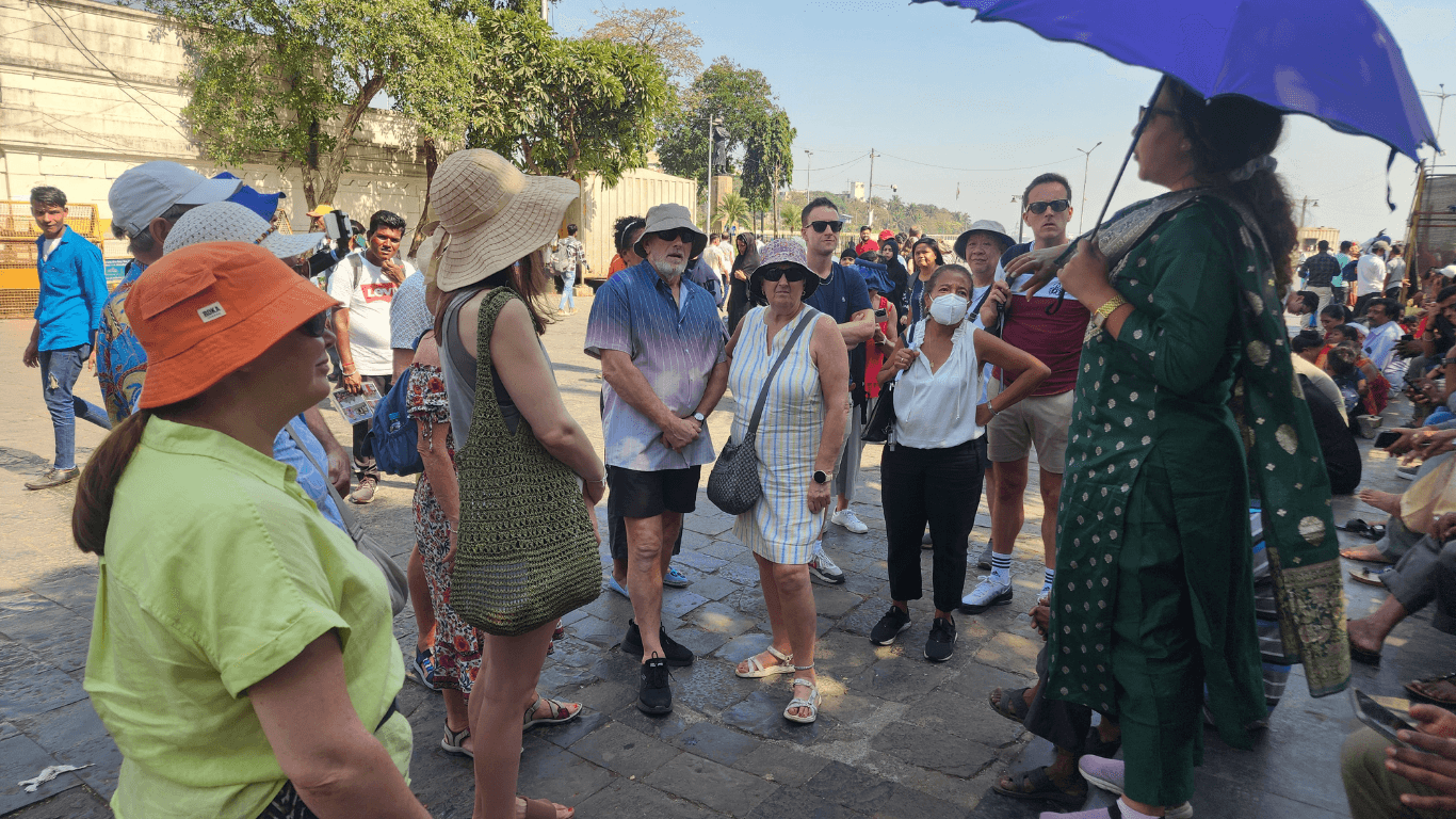 Guided group of international tourists listening to a local guide during a Mumbai city sightseeing tour in India
