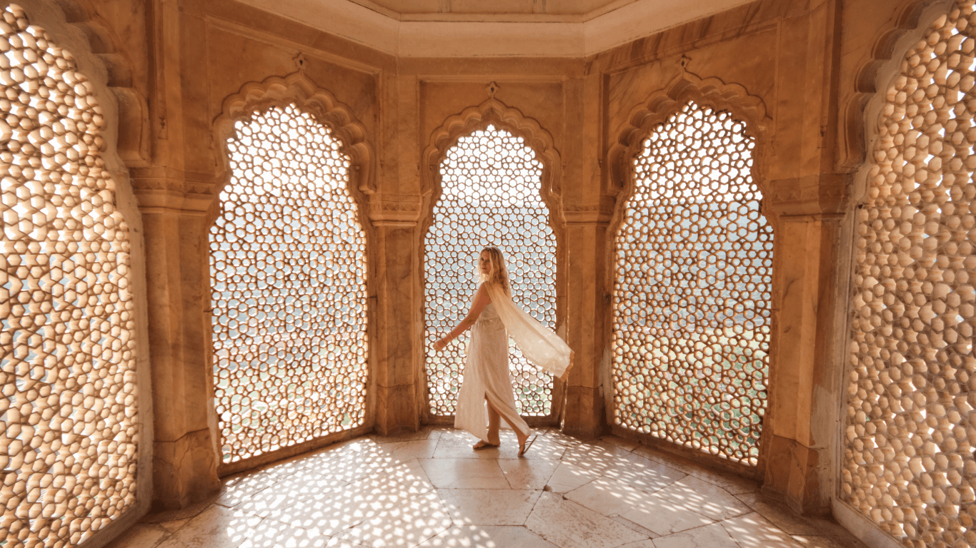 Traveler inside a Mughal heritage monument experiencing intricate jali architecture during a Golden Triangle shore excursion in India
