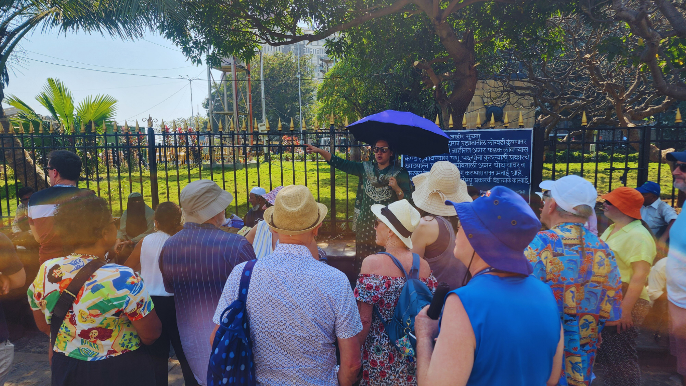 Local guide explaining Mumbai history to tour group during a guided city sightseeing tour