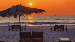 Sunset at Candolim Beach Goa with beach chairs, umbrellas and calm sea