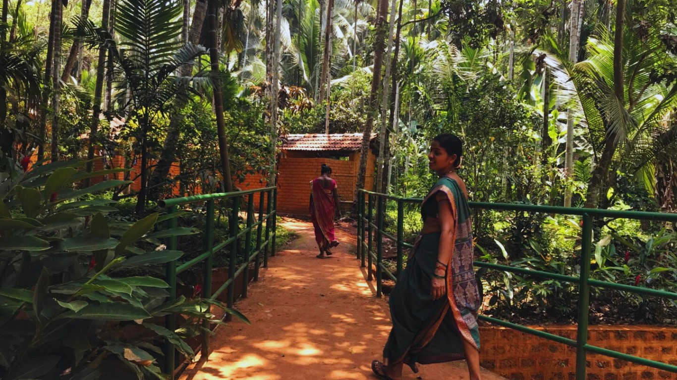 Local woman walking through a spice plantation village in Goa